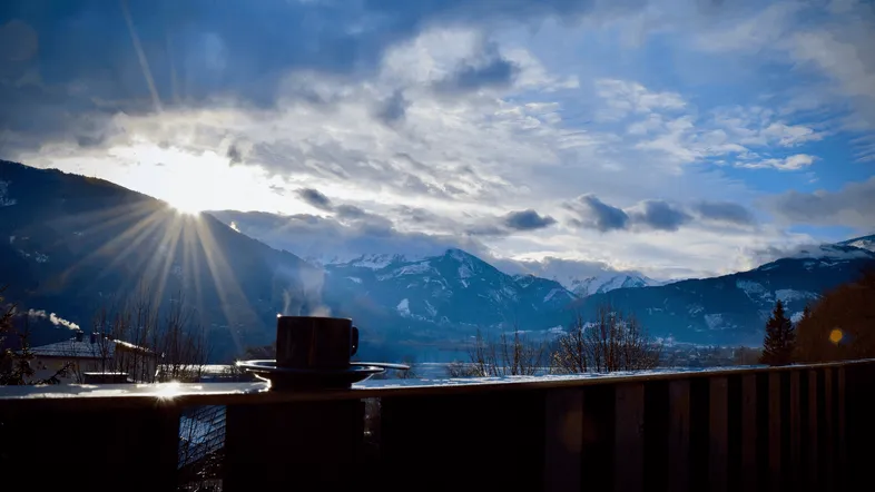 Tasse auf dem Balkon mit atemberaubendem Blick auf die Berge und den See bei Sonnenaufgang.