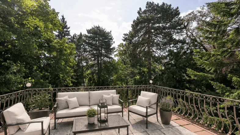 Geräumige Terrasse mit bequemen Gartenmöbeln und einem weiten Blick ins Grüne, ideal zum Entspannen.