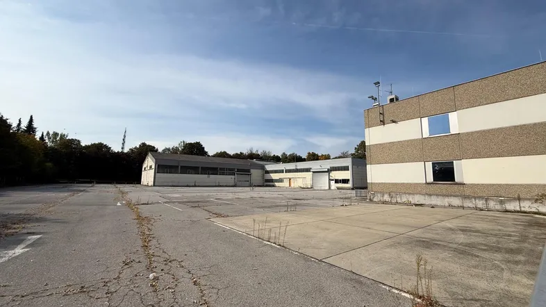 Weitläufiger Außenbereich mit großem Parkplatz und mehreren Industriegebäuden unter bewölktem Himmel.