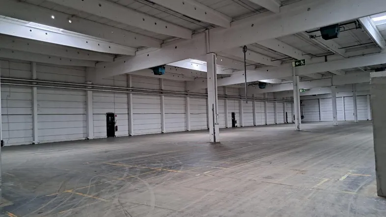 Große, leere Lagerhalle mit hohen Decken und Betonboden, bereit für die Nutzung.