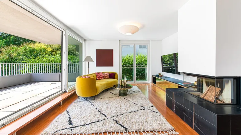 Helles Wohnzimmer mit modernem Kamin, gelbem Sofa und Zugang zur großen Terrasse.