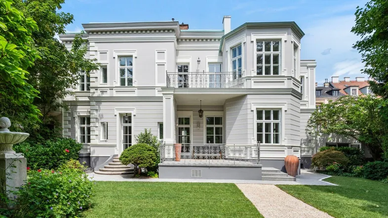 Elegante Stadtvilla mit klassischer Architektur, gepflegtem Garten und mehreren Balkonen.