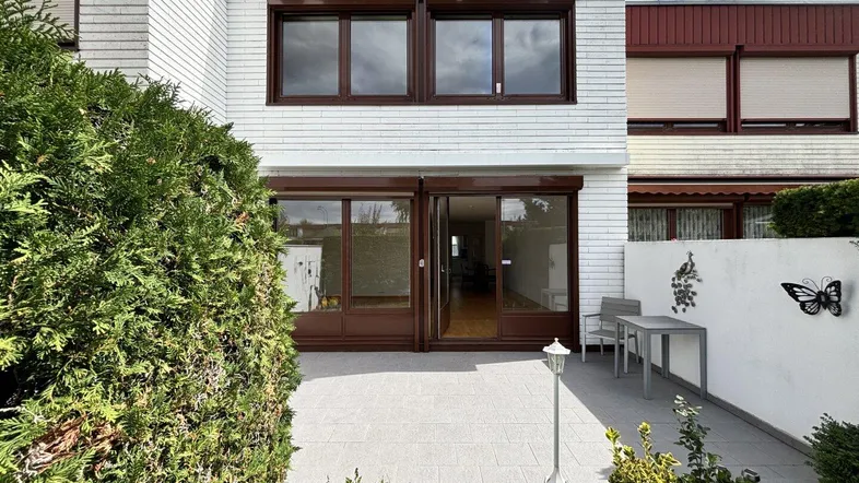 Außenansicht des Reihenhauses mit kleiner Terrasse und Zugang zum Gartenbereich.