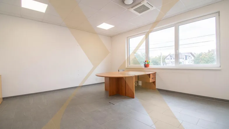 Helles Büro mit großen Fenstern, Holztisch und modernen grauen Fliesenböden, ideal für produktives Arbeiten.