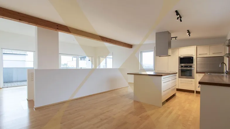 Geräumiger offener Wohn- und Essbereich mit moderner Einbauküche, Holzboden und Zugang zum Balkon.