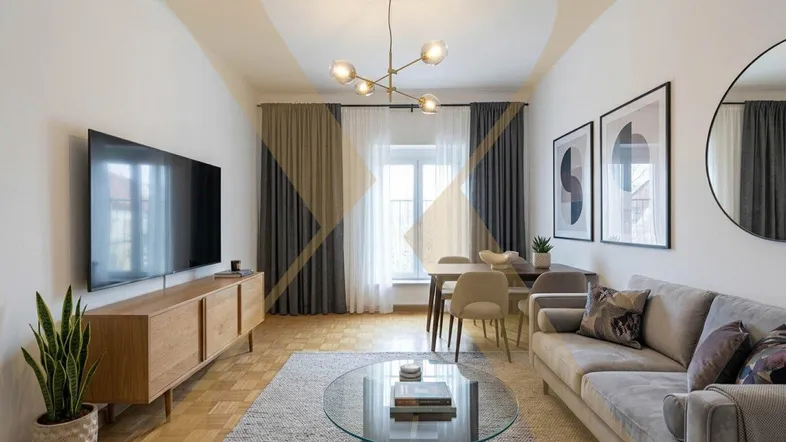 Modern eingerichteter Wohn-Essbereich mit bequemer Couch, Esstisch und einem großen Fernseher.