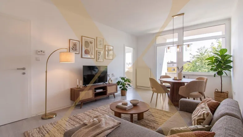 Helles Wohn- und Esszimmer mit moderner Einrichtung, Laminatboden und Zugang zum Balkon.