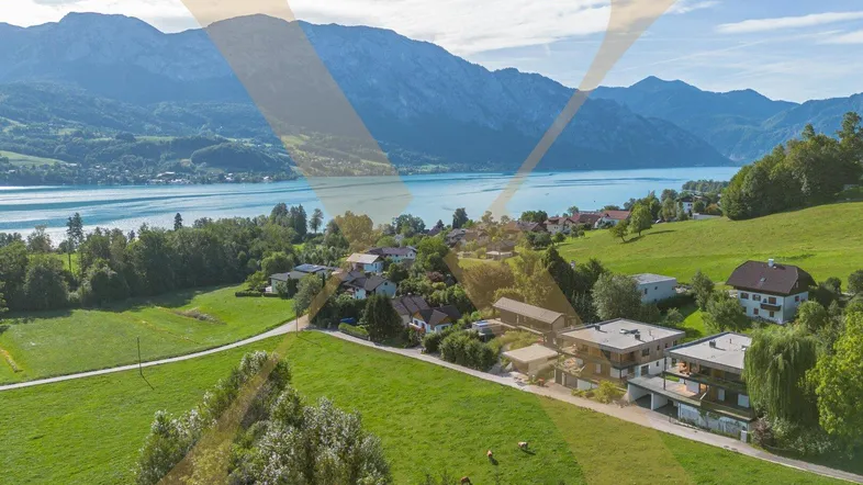 Luftaufnahme der modernen Wohnanlage mit Blick auf den See und die umliegende Berglandschaft.