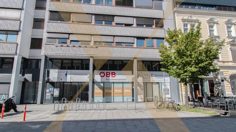 Ansicht der modernen Geschäftsfassade mit großen Fenstern und Fahrradständern auf dem Bürgersteig.