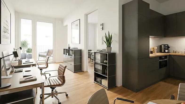 Moderner Büroraum mit mehreren Arbeitsplätzen, Holzboden und integrierter Küchenzeile mit Balkonzugang.
