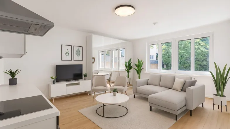 Helles, offenes Wohnzimmer mit integrierter Küche, modernen Möbeln und großen Fenstern.