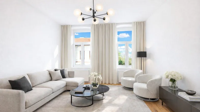 Helles, modern eingerichtetes Wohnzimmer mit beigem Sofa, Teppich und stilvoller Deckenleuchte.