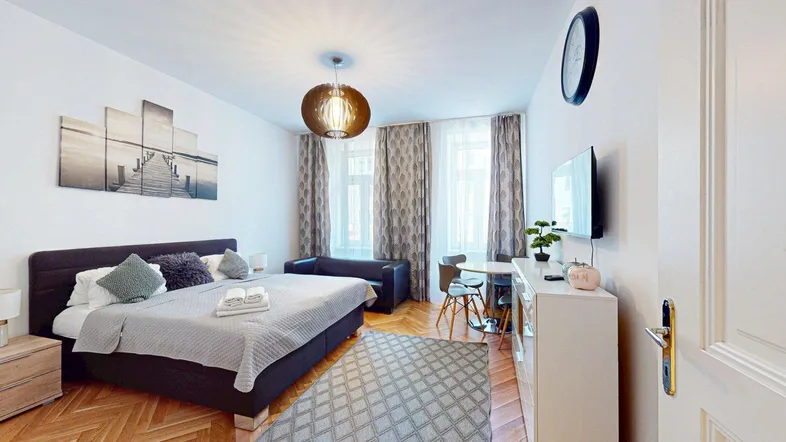 Helles Schlafzimmer mit Parkettboden, Doppelbett und modernem Dekor.