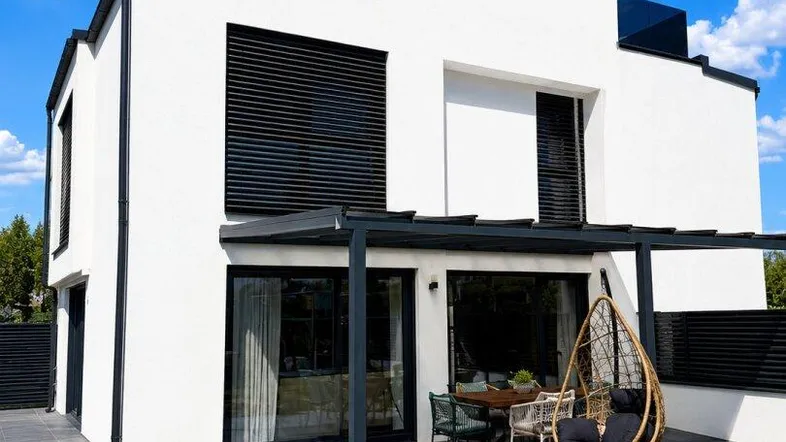 Moderne weiße Villa mit klaren Linien, großen Fenstern und einem eleganten Außenpoolbereich.