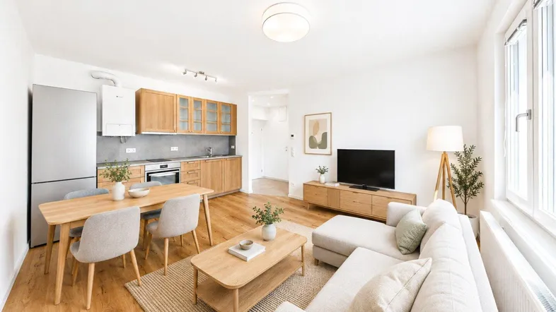 Helles, offenes Wohn- und Esszimmer mit integrierter Küche, Holzboden und moderner Einrichtung.