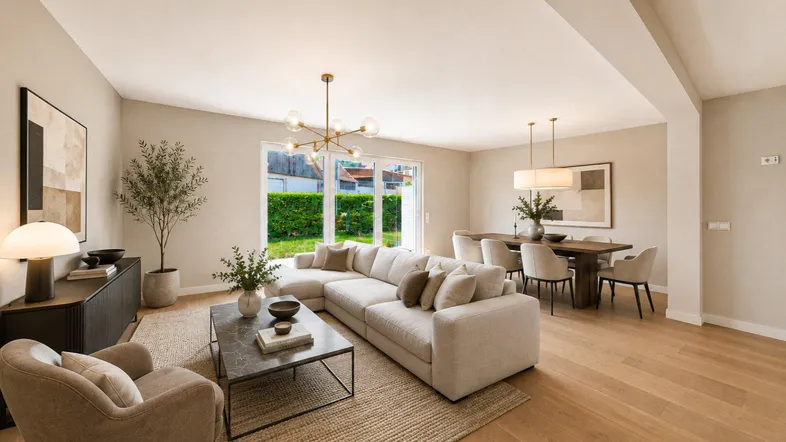 Heller, offener Wohn-Essbereich mit modernem Sofa, Esstisch und Zugang zum grünen Garten.