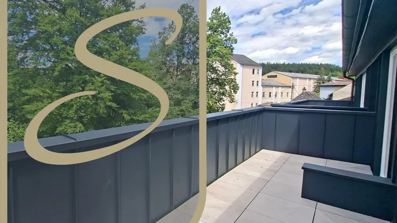 Geräumiger Balkon mit Fliesenboden und Blick ins Grüne sowie auf die umliegenden Gebäude.