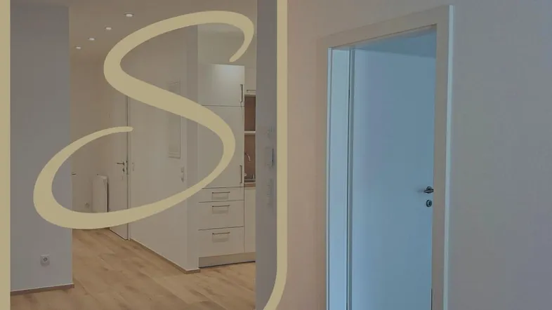 Heller Wohnbereich mit Holzboden und Einbaubeleuchtung, der in eine moderne Küche übergeht.