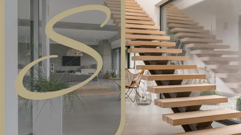 Moderne Holztreppe in einem hellen, offenen Eingangsbereich mit großen Fenstern und Blick ins Wohnzimmer.
