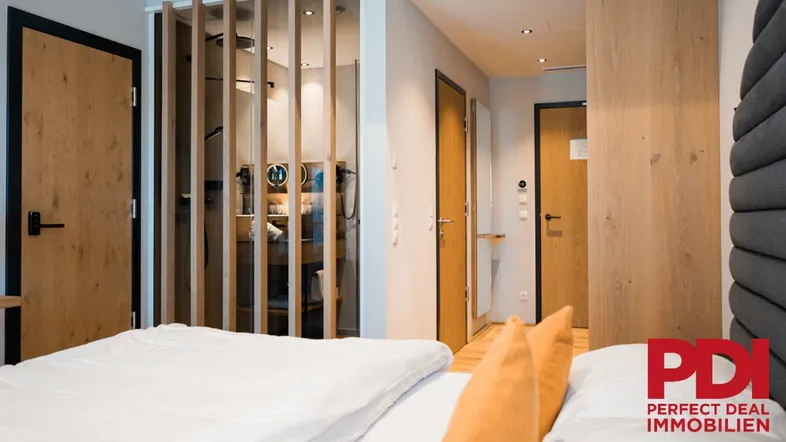 Modernes Schlafzimmer mit Holzelementen, bequemen Betten und stilvoller Raumaufteilung.