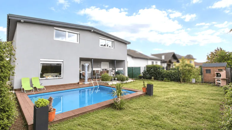 Moderner Neubau mit großem Garten, privatem Pool und Holzterrasse für entspannte Stunden im Freien.