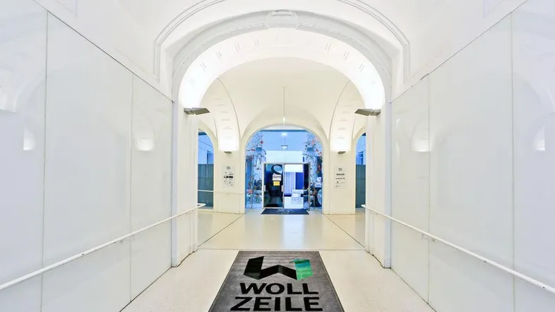 Heller, moderner Flur mit gewölbten Decken und weiß gestrichenen Wänden, der zu weiteren Räumen führt.