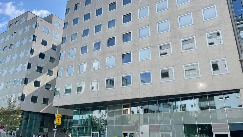 Moderne Bürogebäude-Fassade mit vielen quadratischen Fenstern und Glasfront im Erdgeschoss.