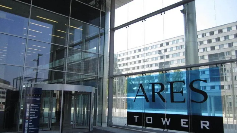 Modernes Gebäude mit großer Glasfassade und Drehtür am Eingangsbereich des Ares Towers.