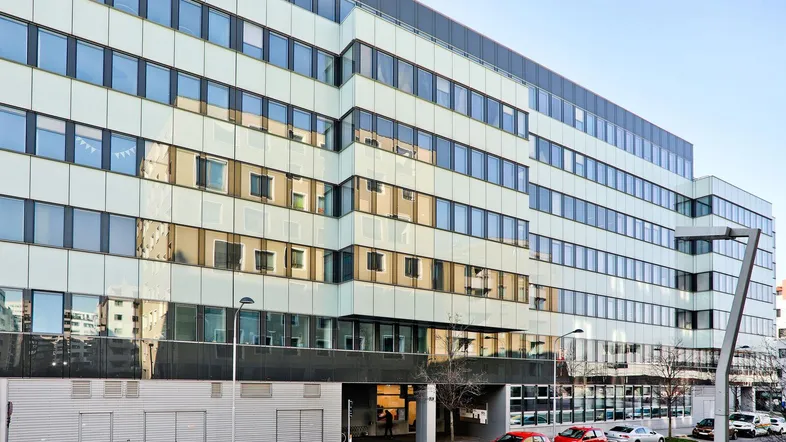 Modernes Bürogebäude mit vielen Fenstern und einer klaren, funktionalen Architektur.