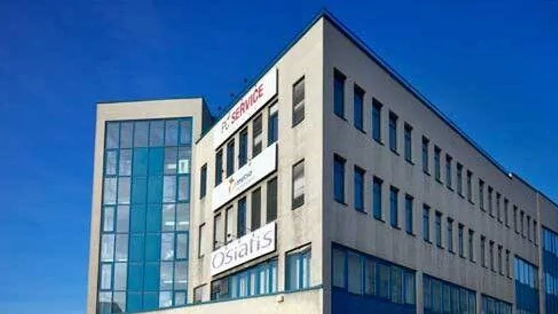 Modernes Bürogebäude mit blauen Glasfassaden und klarem Himmel, das eine zeitgenössische Architektur zeigt.