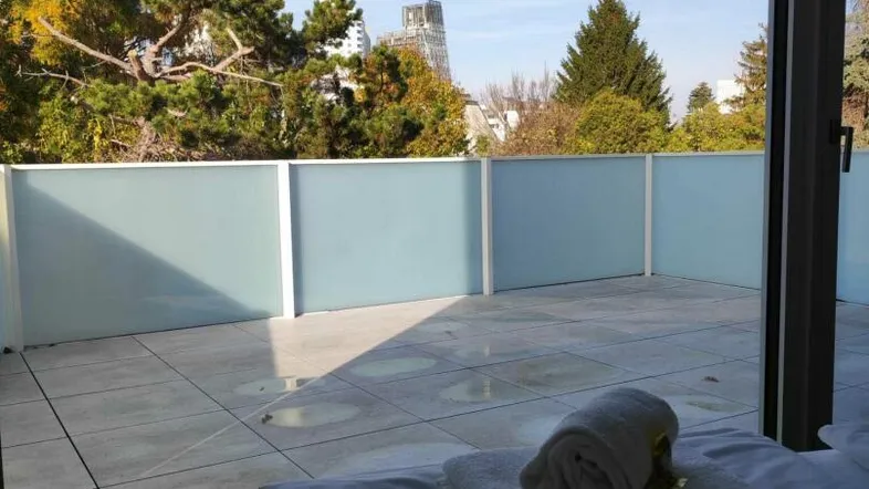 Helles Schlafzimmer mit Zugang zu einer großen Terrasse und Blick ins Grüne.