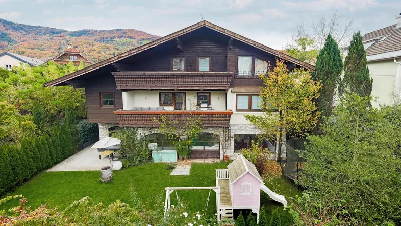Charmantes Haus mit großem Garten, Spielplatz und Bergblick in herbstlicher Umgebung.