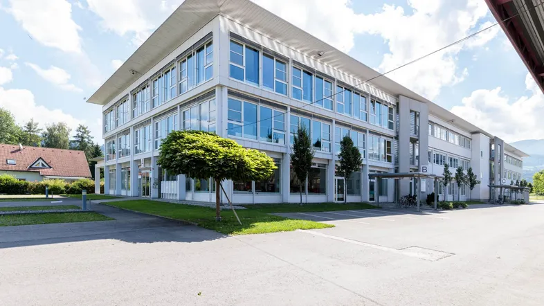 Weitläufige Ansicht eines modernen Bürokomplexes mit Grünflächen und Parkmöglichkeiten.