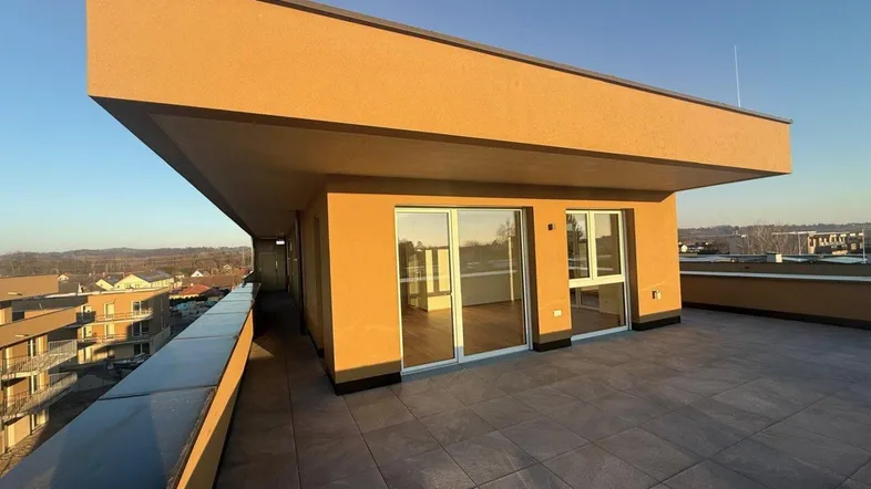 Geräumige Dachterrasse mit modernen Fliesen und weitem Blick über die Umgebung.