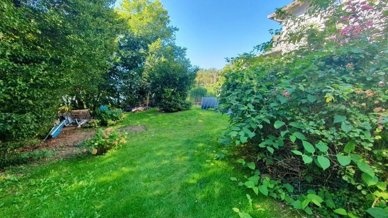 Weitläufiger Garten mit Rasenfläche, altem Baumbestand und viel Privatsphäre.