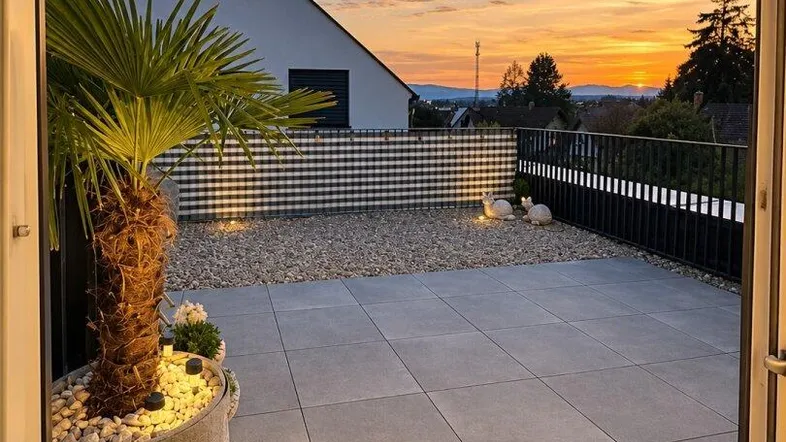 Große geflieste Terrasse mit Palmen und Kies, bietet einen wunderschönen Blick auf den Sonnenuntergang über die Landschaft.