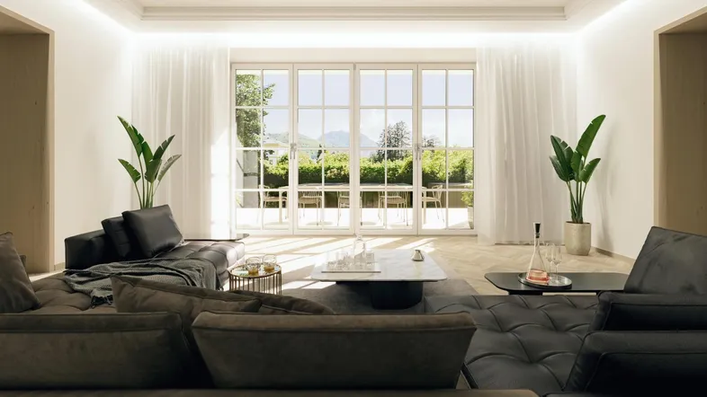 Helles, modernes Wohnzimmer mit großen Fenstern, dunklen Sofas und Blick auf die Berge und Natur.