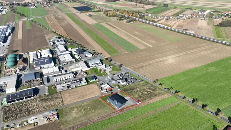 Luftaufnahme eines Gewerbeobjekts mit umliegenden Feldern und ländlicher Infrastruktur.