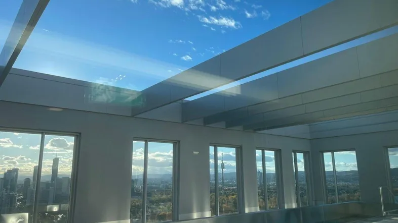 Heller, verglaster Bereich mit Panoramablick auf die Stadt und den Himmel, ideal zum Entspannen.