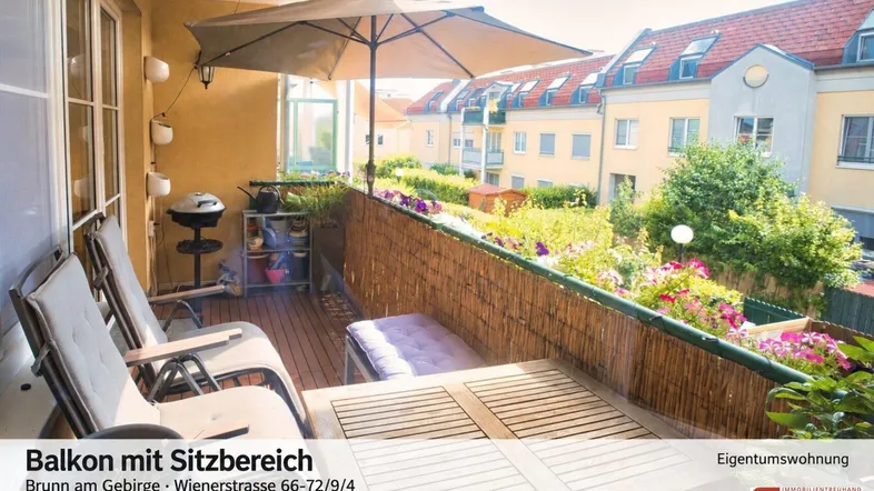 Gemütlicher Balkon mit Sitzbereich, Sonnenschirm und vielen Pflanzen, ideal zum Entspannen im Freien.