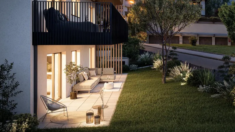 Abendliche Ansicht einer möblierten Terrasse mit angrenzendem Gartenbereich und stimmungsvoller Beleuchtung.