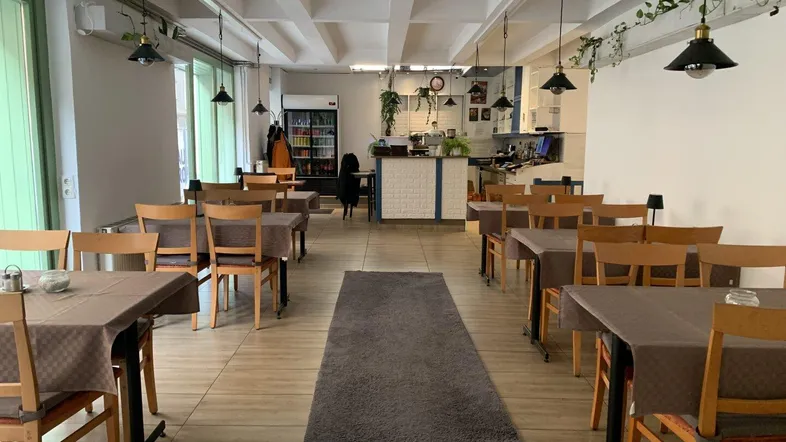 Geräumiger Essbereich mit mehreren Tischen und Stühlen, ideal für ein Restaurant oder Café.