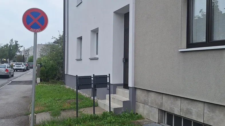 Außenansicht eines modernen Mehrfamilienhauses mit weißer und grauer Fassade.