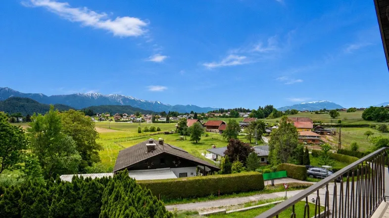 Panoramablick vom Balkon auf die umliegende Landschaft mit Bergen in der Ferne.