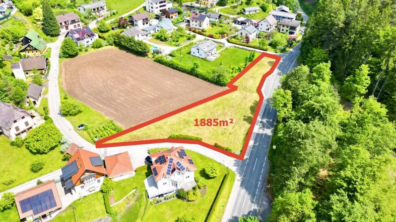 Luftaufnahme eines Baugrundstücks von 1885m² umgeben von Wohnhäusern und viel Grün.