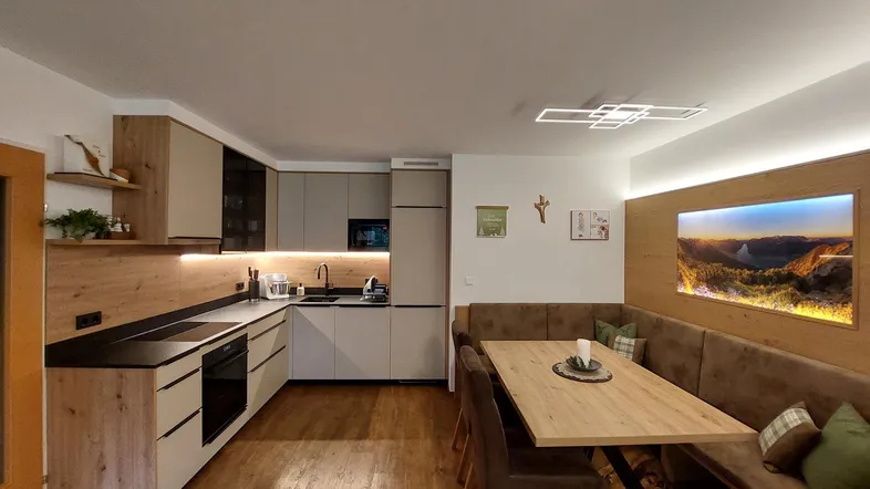 Moderne offene Küche mit Essbereich, Holzboden und integrierten Geräten für gesellige Stunden.