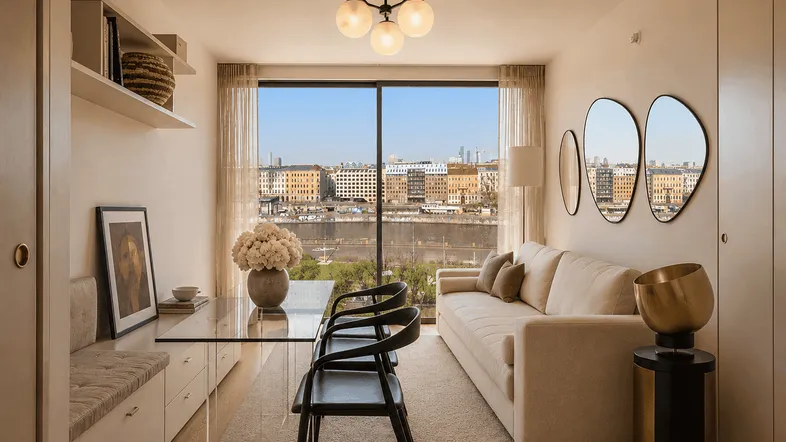 Helles Wohn- und Esszimmer mit moderner Einrichtung, großem Fenster und Stadtblick.