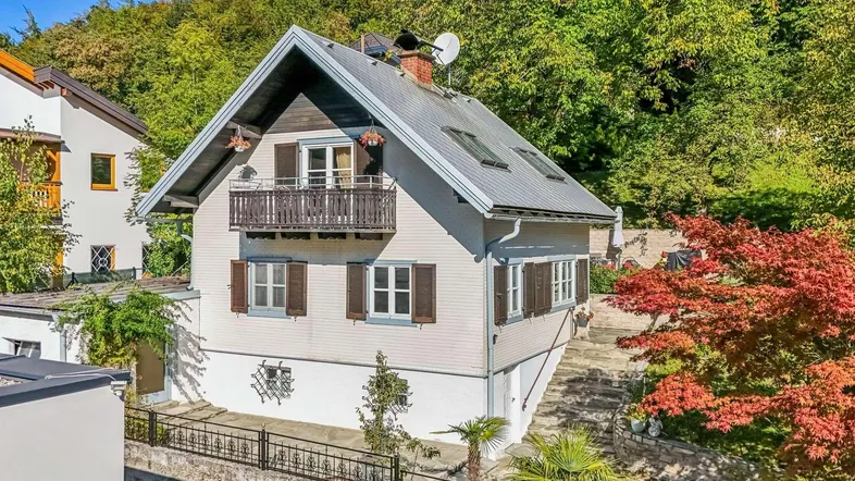 Charmantes Einfamilienhaus mit Satteldach, Balkon und grüner Umgebung.