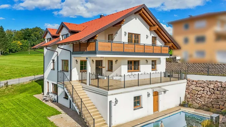Modernes Einfamilienhaus mit Pool, großzügigen Balkonen und gepflegtem Gartenbereich.