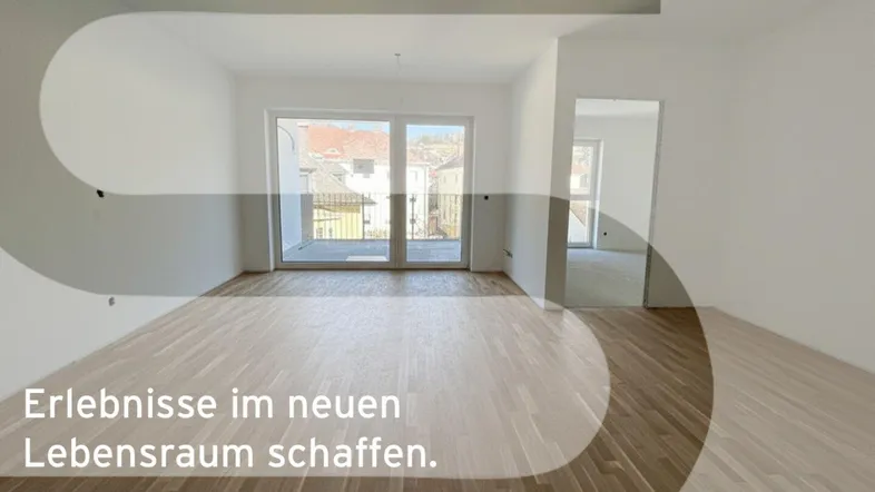 Heller, leerer Raum mit hochwertigem Parkettboden und großen Fenstern mit Zugang zu einem Balkon.